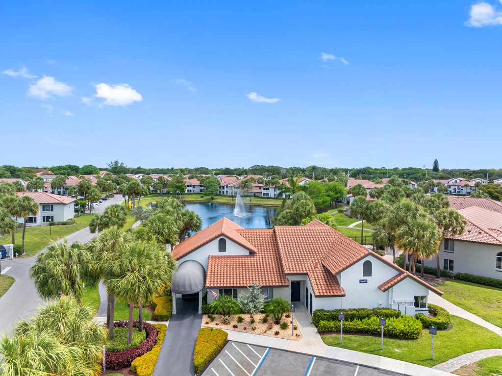 A view of a residential area with a house in the foreground and a body of water in the background.
